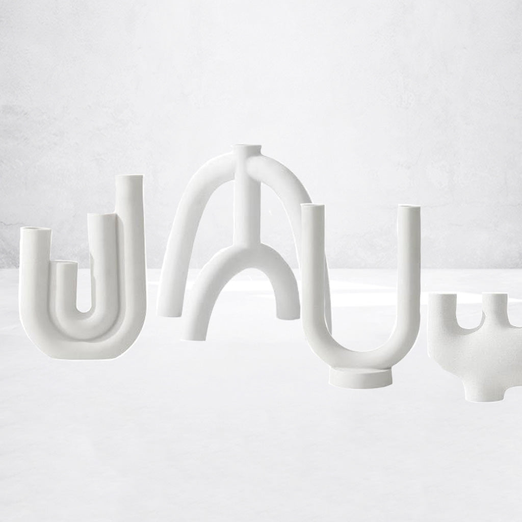 White ceramic candleholders featuring an abstract and artful design, by maoma art